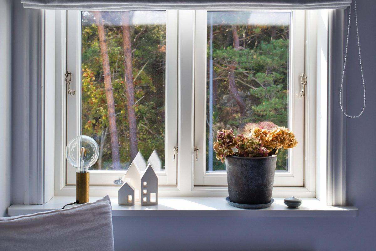 Fönster med krukväxt och små hus som dekoration