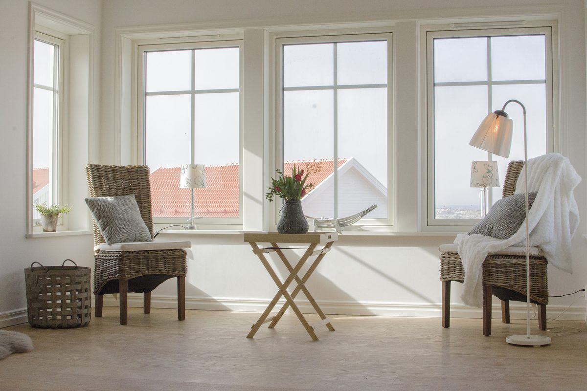 Två stolar och ett litet bord framför en stor glasad gavel